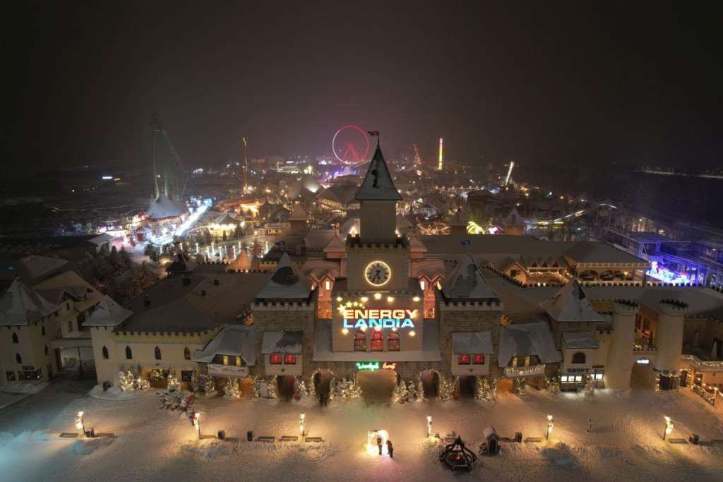 „Zimowy widok na Energylandię nocą podczas Winter Kingdom – oświetlony park rozrywki i główne wejście w śnieżnej scenerii.”