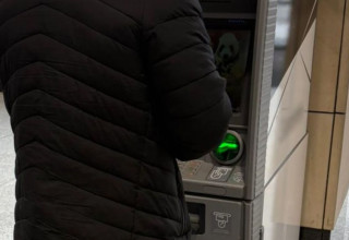 "Osoba stojąca przy bankomacie"