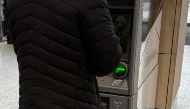 "Osoba stojąca przy bankomacie"